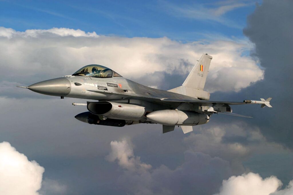 General Dynamics F16 Fighting Falcon jet flying above clouds showcasing sleek design and power Wallpaper