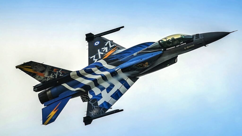 General Dynamics F-16 Fighting Falcon with blue white graphics flying in clear blue sky wallpaper