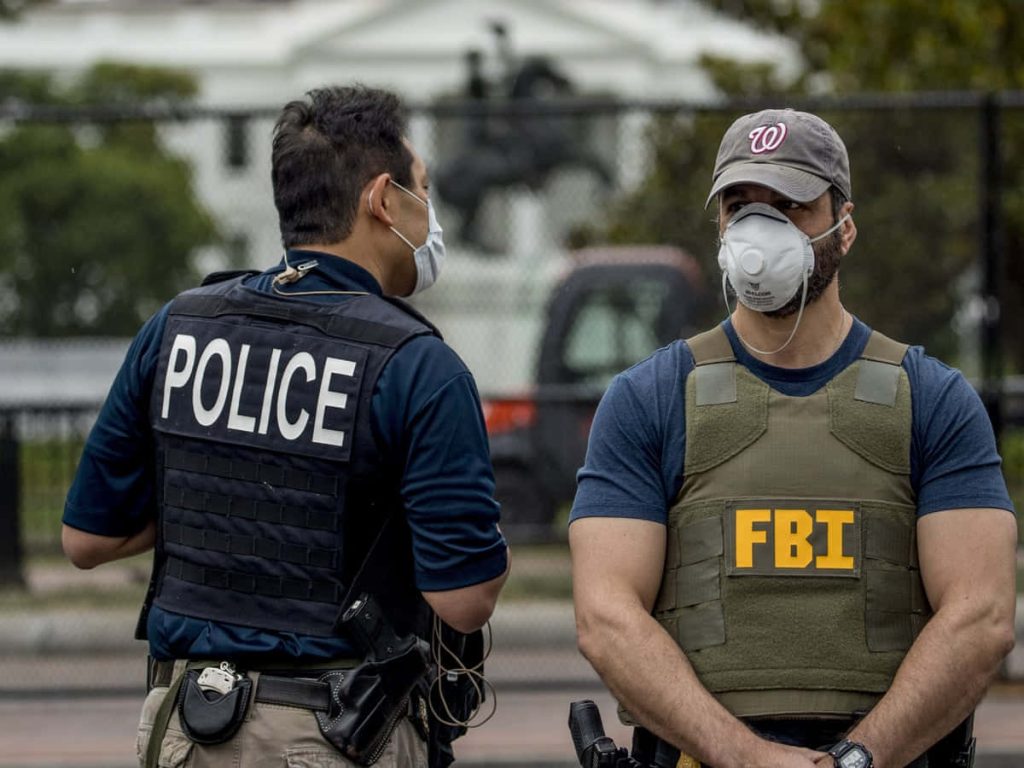 Police officer and FBI agent wearing masks guard outside White House tactical vest wallpaper