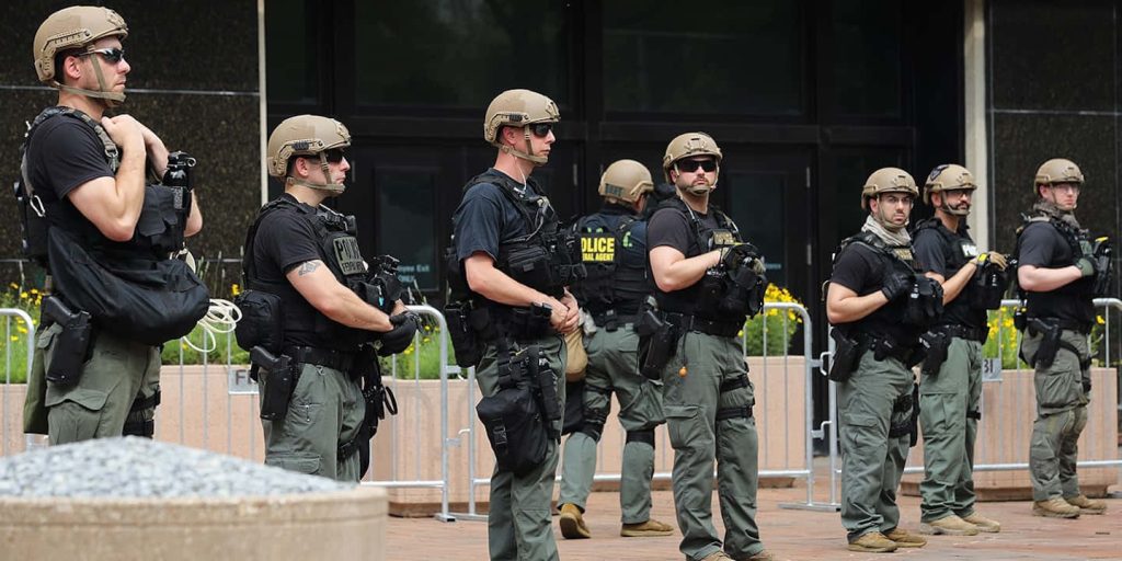 FBI agents and police officers in black tactical gear guarding building in high-definition wallpaper