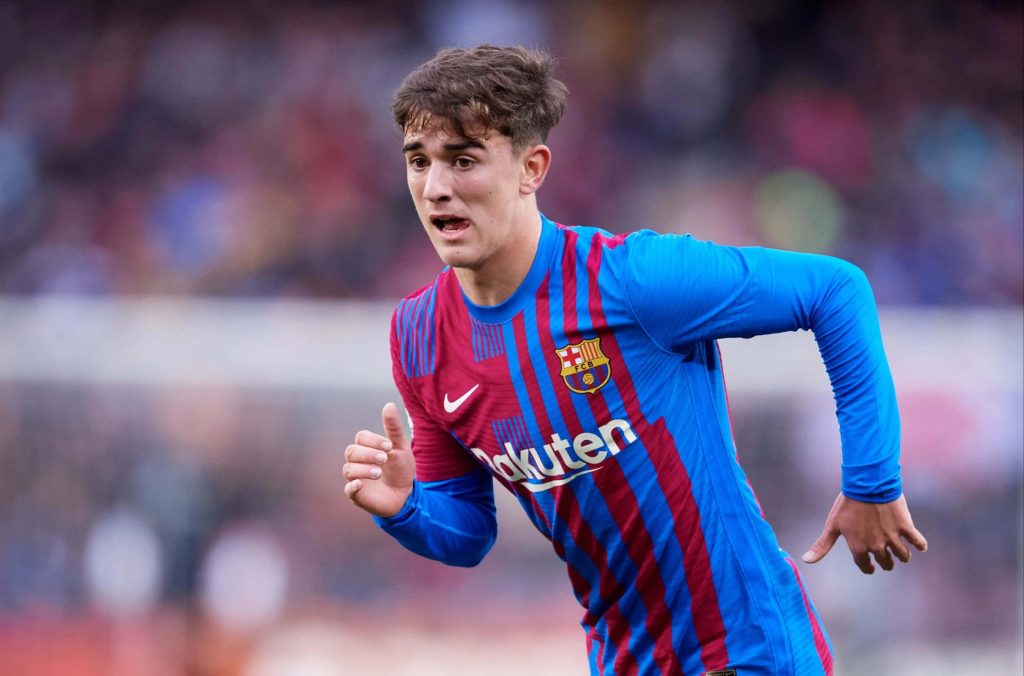 FC Barcelona midfielder Gavi in blue red kit running focused stadium backdrop football wallpaper