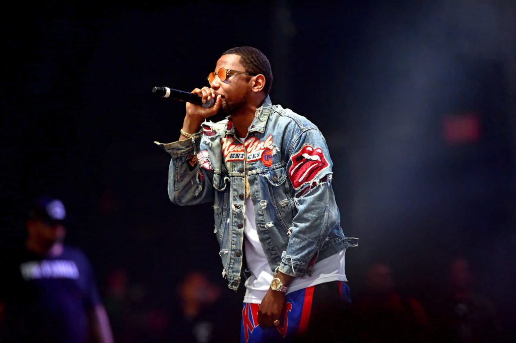 Rapper Fabolous live performing in denim jacket and orange sunglasses dramatic stage lighting Wallpaper