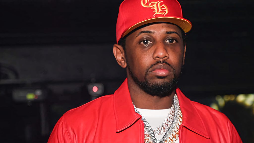 Crisp portrait of rapper Fabolous in red leather jacket red cap and diamond chains on dark background Wallpaper