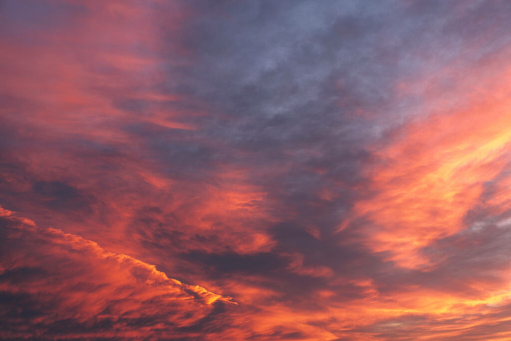 Fiery Sky Embrace: Breathtaking 4K Background Photo of a Setting Sun Illuminating the Horizon with Captivating Red, Orange, and Purple Hues Wallpaper