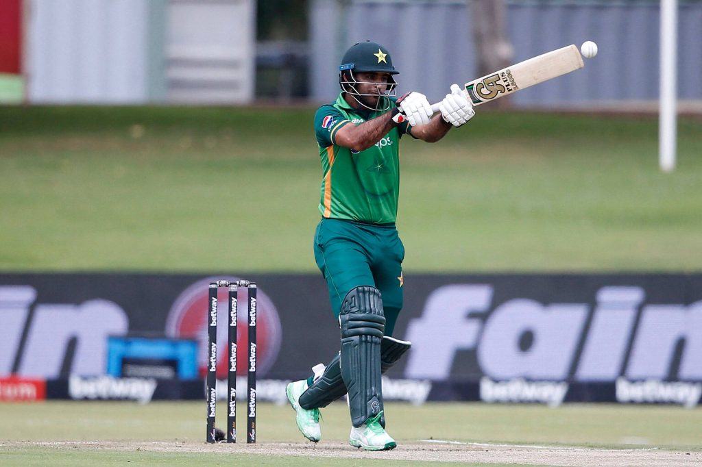 Pakistani cricketer Fakhar Zaman hitting a powerful shot in green uniform on cricket pitch Wallpaper