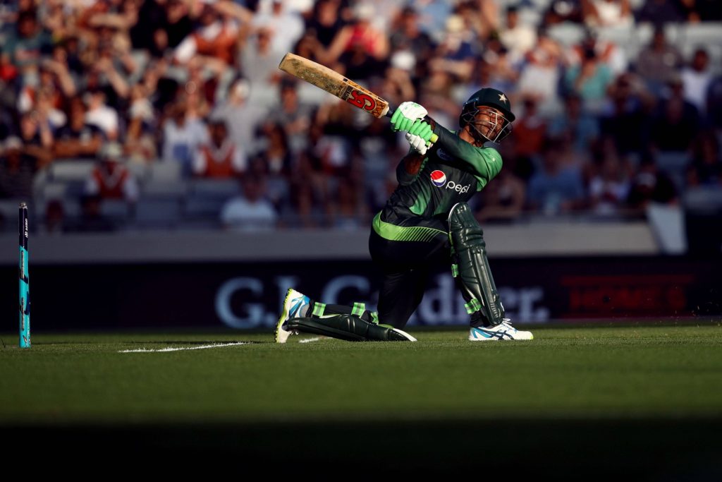 Fakhar Zaman Pakistani cricketer kneeling strike dark green kit CA bat sunlit pitch wallpaper