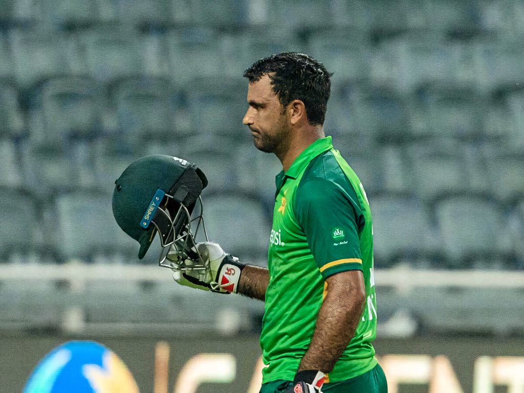 Side view of Fakhar Zaman in green jersey holding helmet and gloves sweaty intense cricket wallpaper