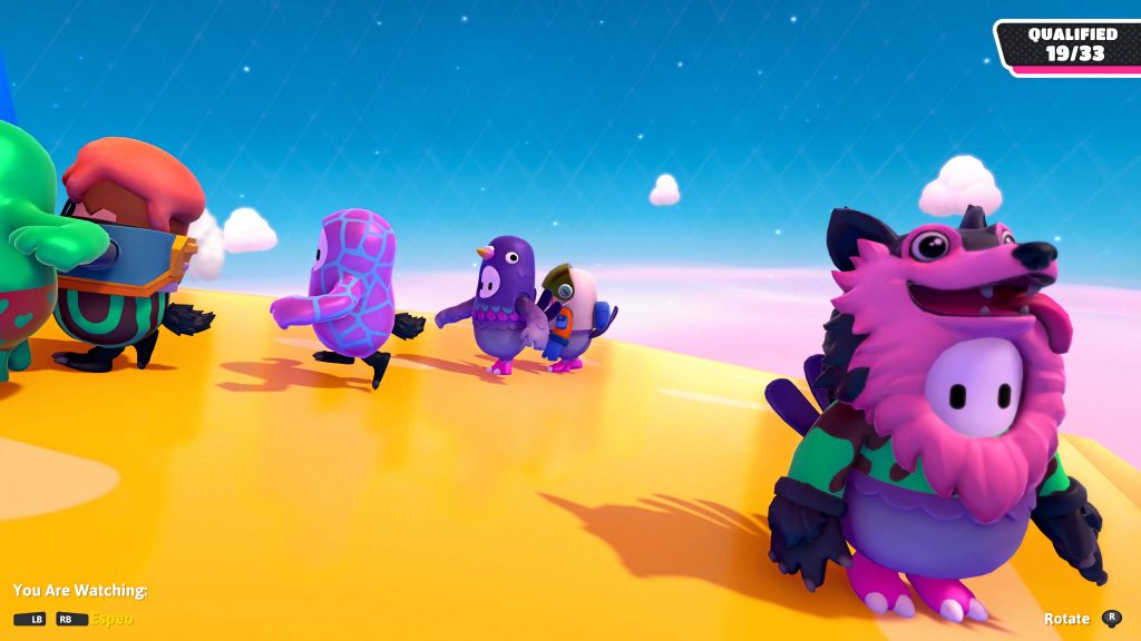 Fall Guys chase scene with colorful costumes racing in bright yellow arena under blue sky Wallpaper