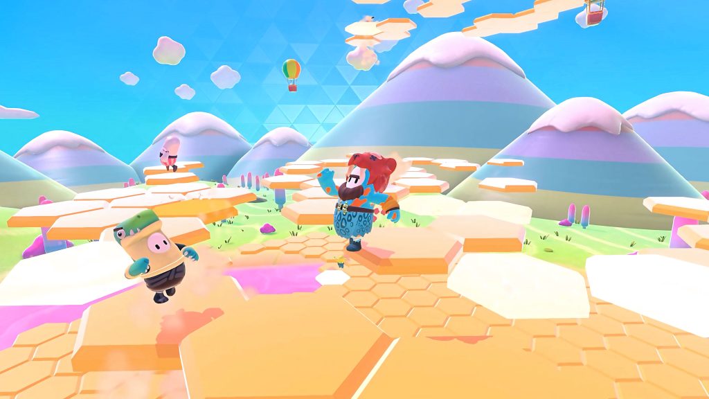 Fall Guys Ultimate Knockout beans in colorful costumes racing on yellow hexagons with mountains Wallpaper
