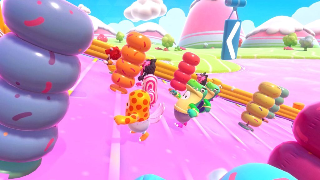 Fall Guys characters in dinosaur and polka-dot costumes racing down pink slime slide wallpaper