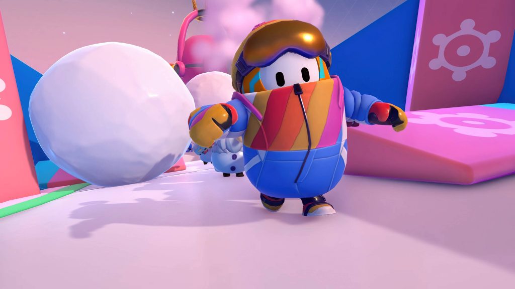 Fall Guys bean in colorful retro ski suit racing past snowballs on vibrant snowy slopes wallpaper