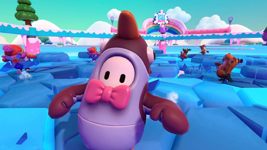 Fall Guys character in brown horned costume breaking icy tiles in snowy colorful game scene Wallpaper