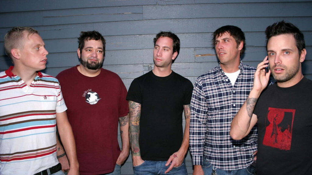 Fall Out Boy band members standing together against blue wall perfect cell phone wallpaper background