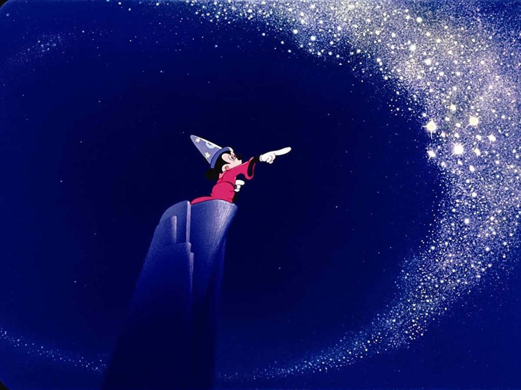 Mickey Mouse Sorcerers Apprentice wallpaper casting sparkling magic stars on dark rocky peak