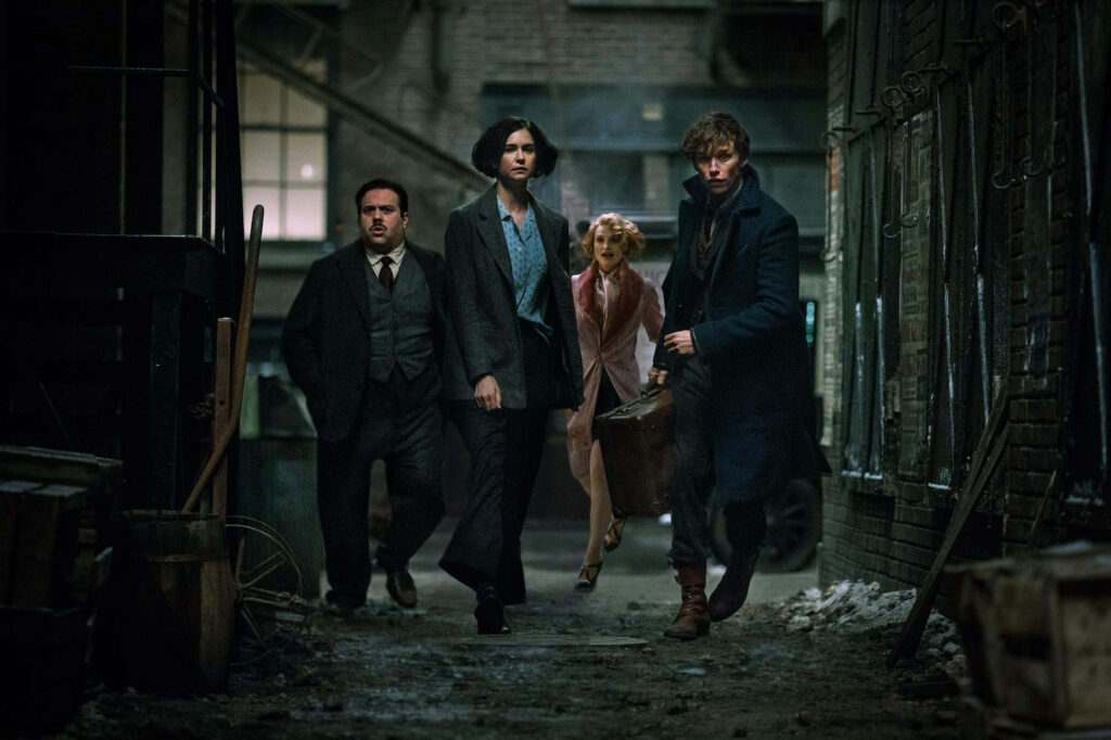 Fantastic Beasts characters walk through dark alley magical suspenseful film wallpaper background