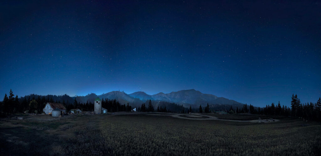 Majestic Nocturnal Landscape: Far Cry 5 Farmstead amidst Enchanting Woodlands and Towering Peaks Wallpaper