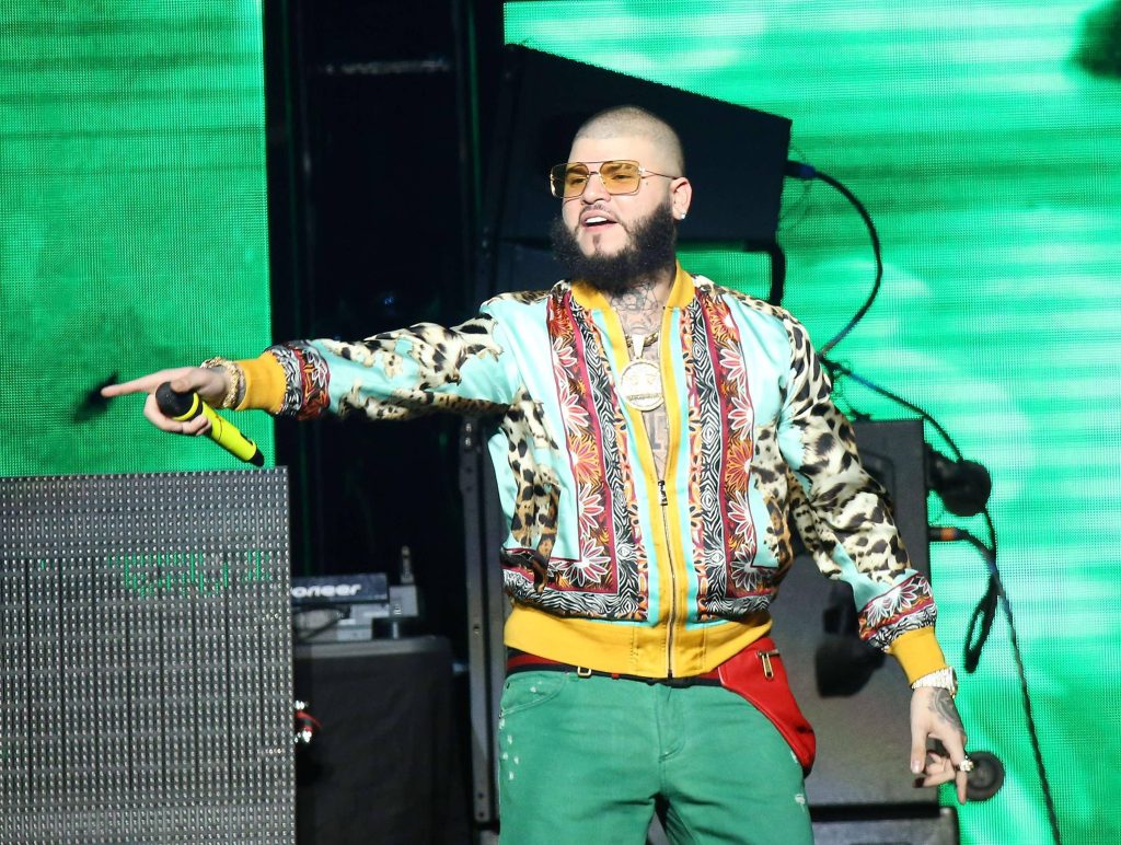 Reggaeton star Farruko performing live in patterned jacket and sunglasses with yellow mic Wallpaper