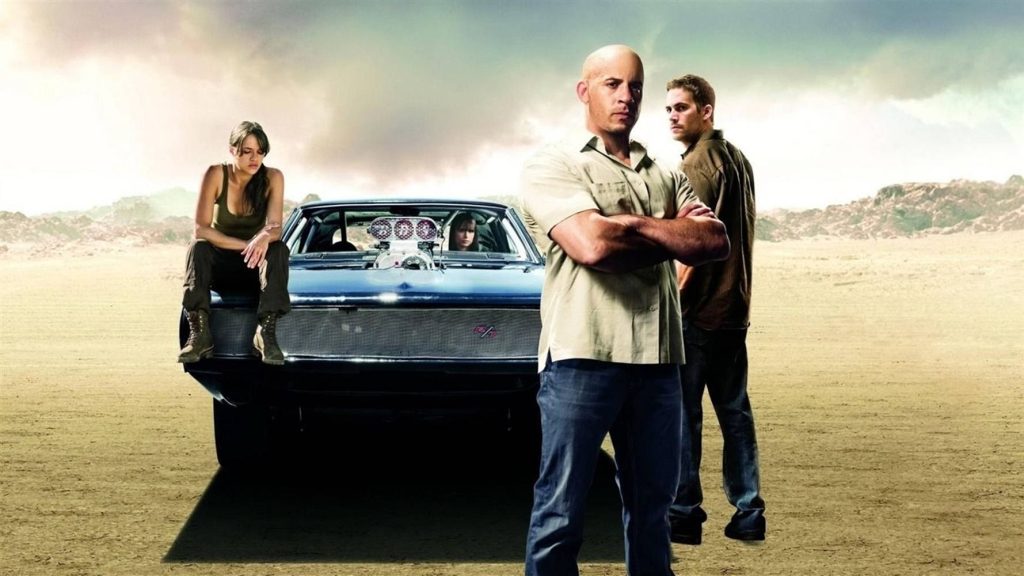 Fast and Furious original cast with muscle car in desert intense cinematic wallpaper background