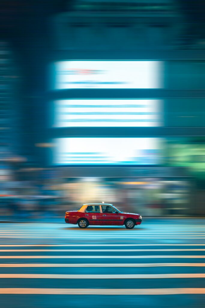 Dynamic Red Taxi Night Scene - Urban Excitement Wallpaper