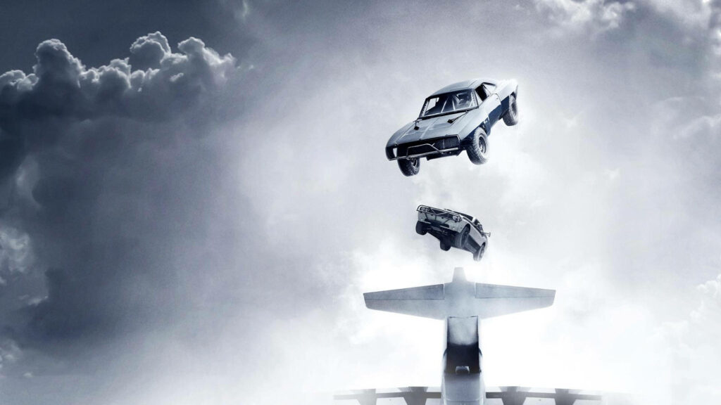 Fast and Furious wallpaper cars jumping from airplane in dramatic cloudy sky action scene