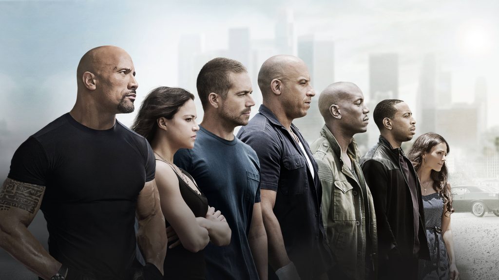 Fast and Furious cast with Dwayne Johnson Vin Diesel and muscle car in urban backdrop wallpaper