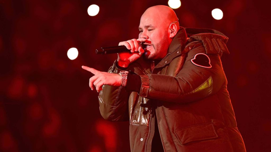 Fat Joe live performance in dark parka red stage lighting blurred bokeh background wallpaper