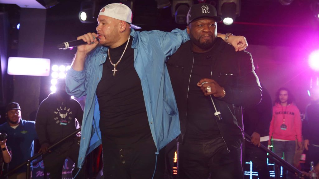 Fat Joe and 50 Cent live on stage under purple lights authentic hip hop concert wallpaper background