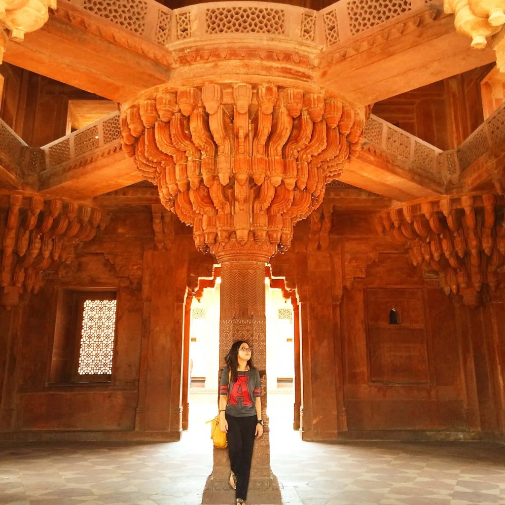 Visitor at Diwan-e-Khas Fatehpur Sikri carved sandstone pillar Mughal architecture travel view Wallpaper
