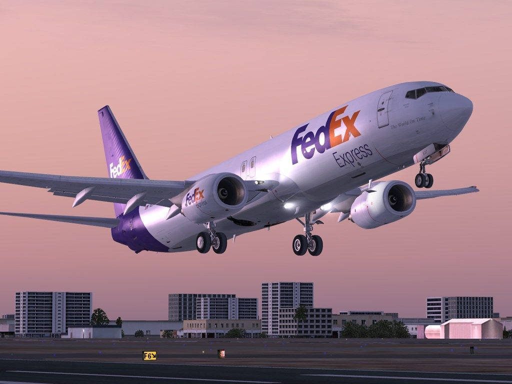 FedEx Express cargo jet lifts off at sunset over city skyline detailed flight simulation art wallpaper