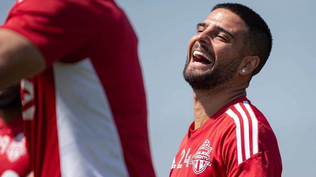 Federico Bernardeschi laughing in Toronto FC red jersey training outdoors bright background wallpaper