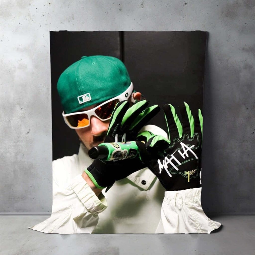Colombian singer Feid portrait green cap white sunglasses branded gloves holding microphone wallpaper