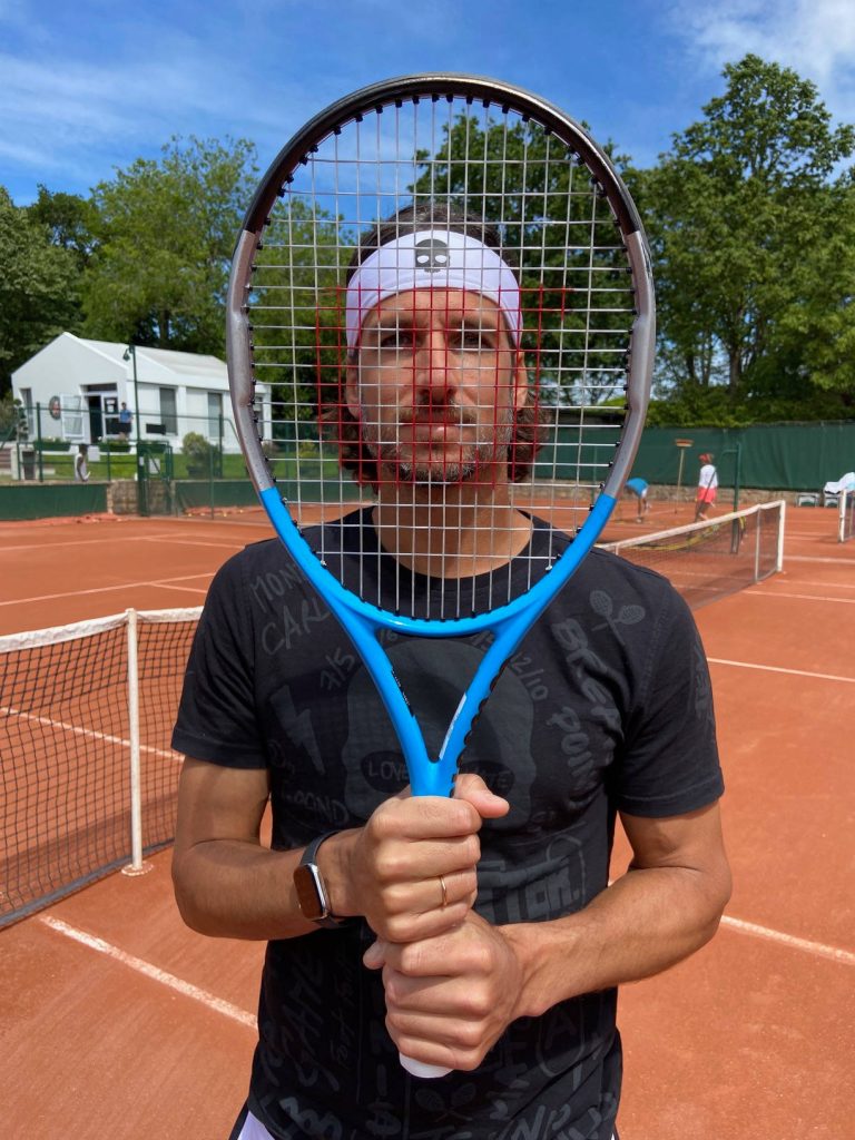 Feliciano López on clay tennis court holding blue racket wearing skull headband and black tee Wallpaper