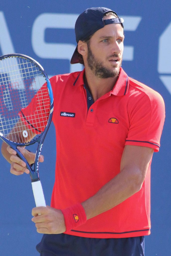 Professional tennis player Feliciano López in red Ellesse shirt focused on court action Wallpaper