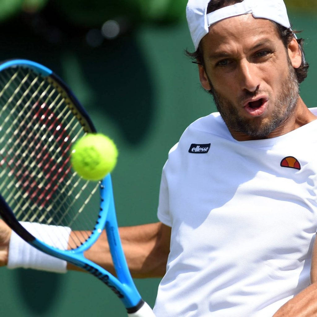 Feliciano López mid-swing with blue racket hitting yellow ball at Delray Beach Open tennis court Wallpaper