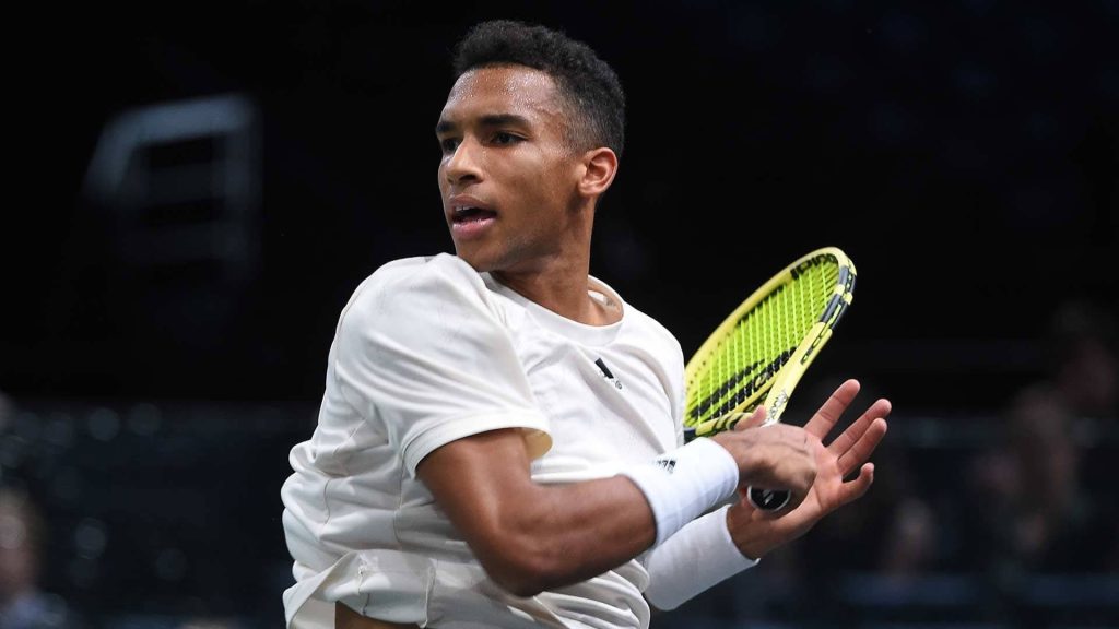 Felix Auger Aliassime powerful forehand swing tennis action shot neon racket wallpaper