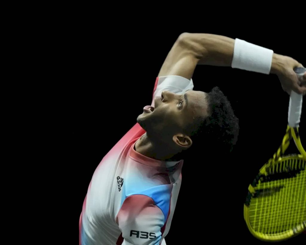 Felix Auger Aliassime mid-serve tennis action Adidas shirt yellow racquet black background wallpaper