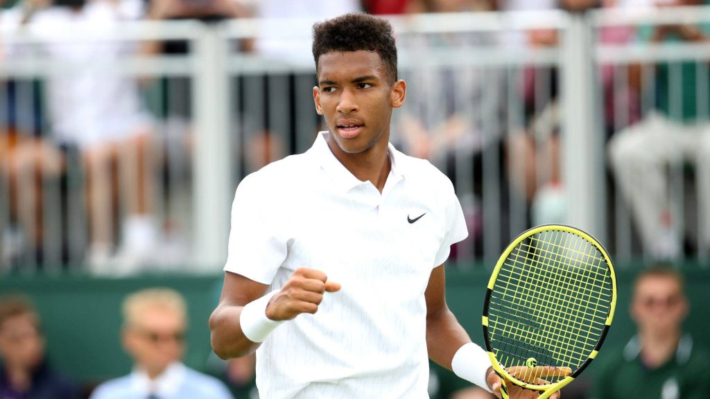 Felix Auger-Aliassime tennis action fist pump white Nike polo vibrant tennis racket wallpaper
