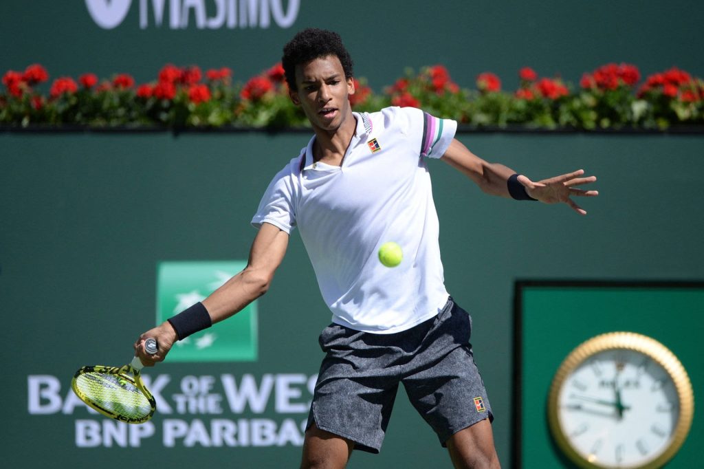 Félix Auger-Aliassime swinging racket on green court BNP Paribas Open tennis wallpaper background