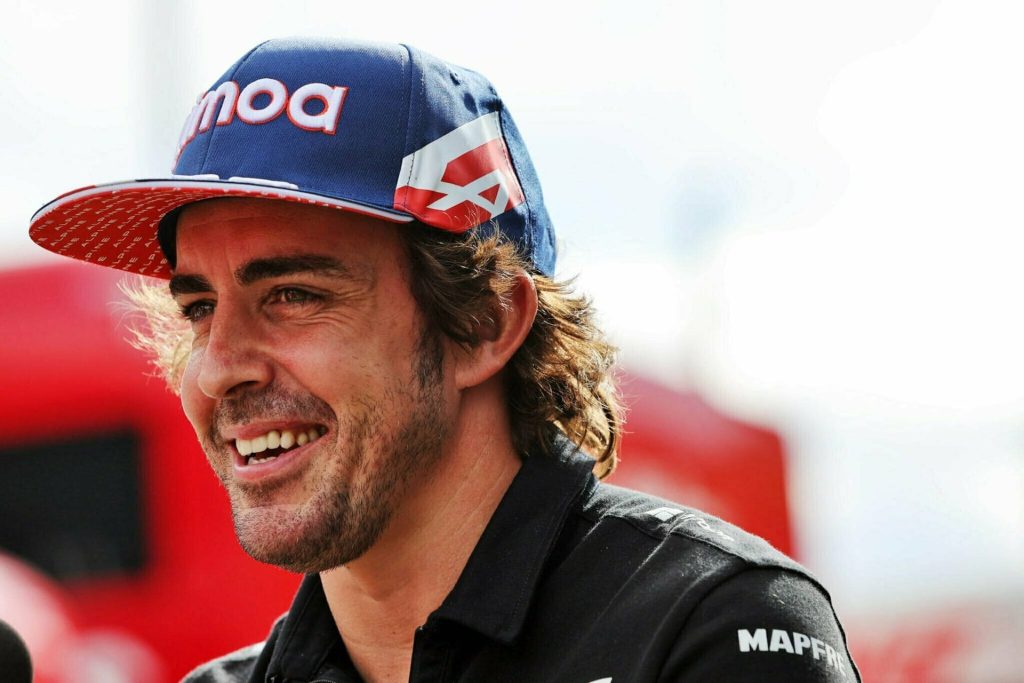 Fernando Alonso close-up portrait smiling in Alpine F1 cap black gear vibrant F1 wallpaper background