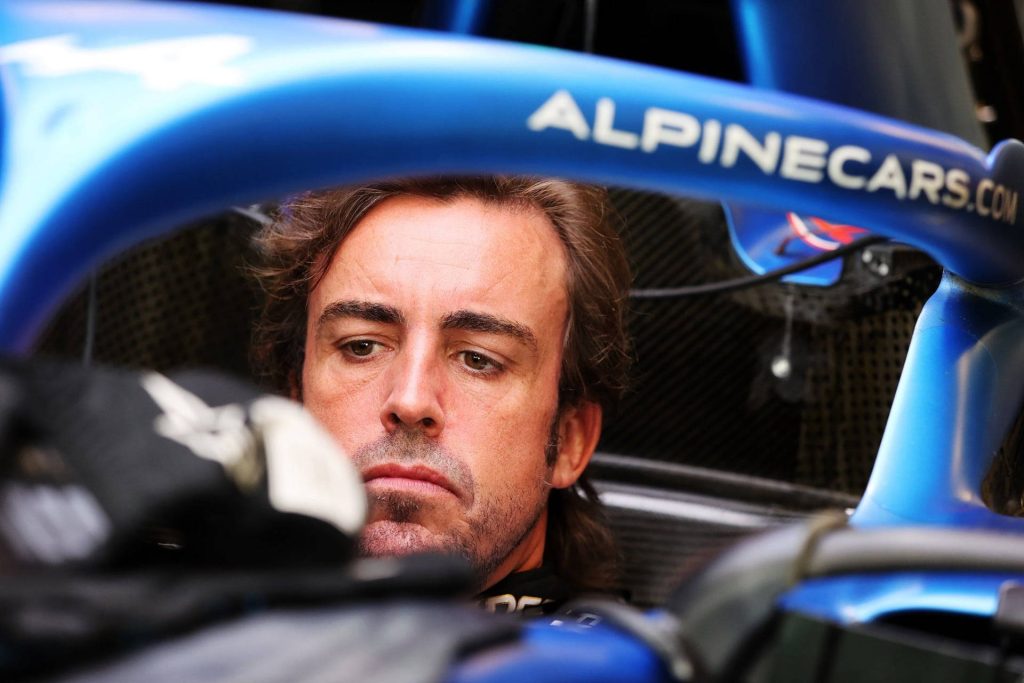 Close-up of Fernando Alonso focused in blue Alpine F1 cockpit intense Formula 1 racing wallpaper