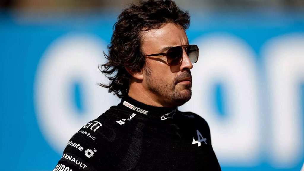 Fernando Alonso Alpine F1 driver in dark sunglasses sharp portrait blue background wallpaper