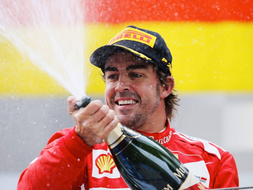 Fernando Alonso Ferrari podium celebration spraying champagne vibrant Formula 1 wallpaper