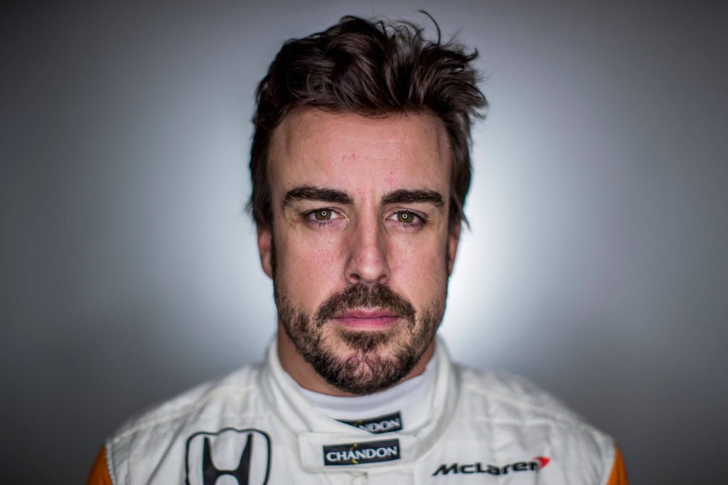 Close-up portrait of F1 champion Fernando Alonso in McLaren-Honda racing suit studio background Wallpaper