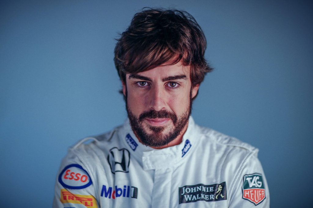 Fernando Alonso in white McLaren Honda racing suit with TAG Heuer Esso logos on blue background Wallpaper
