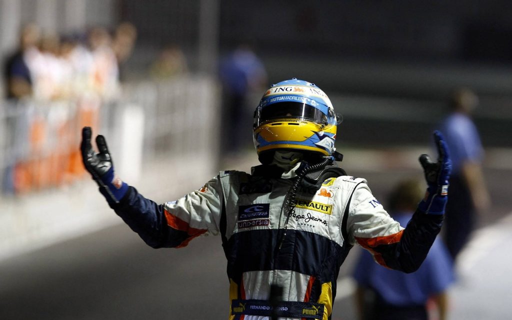 Fernando Alonso Renault F1 driver in victory pose with helmet and racing suit on track background Wallpaper