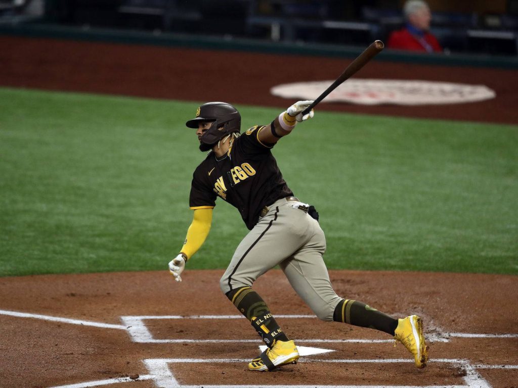 Fernando Tatis Jr swinging bat in San Diego Padres uniform on brown gold infield dirt wallpaper