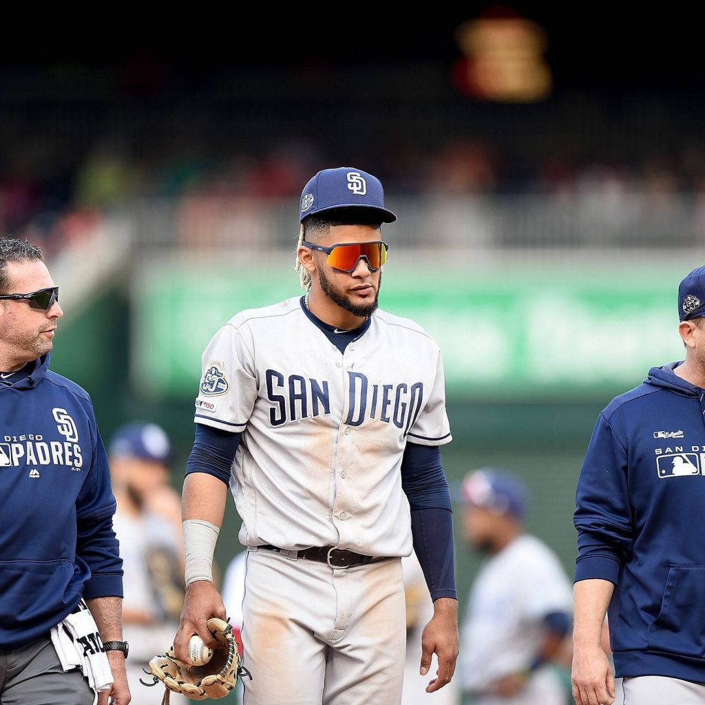 Fernando Tatis Jr San Diego Padres in gray jersey and reflective orange shades on baseball field Wallpaper