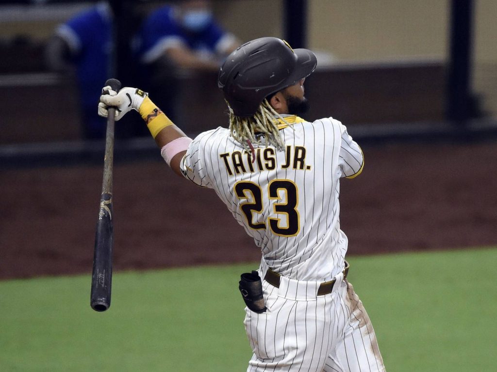 Fernando Tatís Jr swinging for a home run in white pinstripe San Diego Padres uniform wallpaper