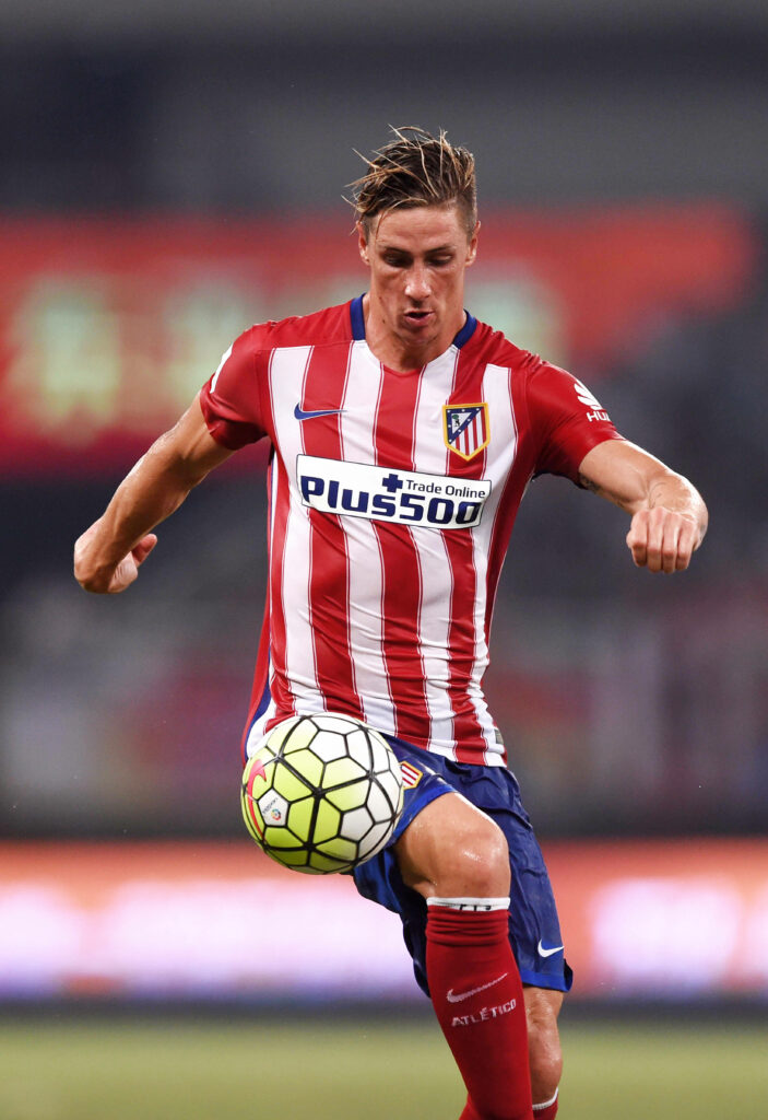 Fernando Torres in Atletico Madrid kit charges forward with intense focus on football field wallpaper