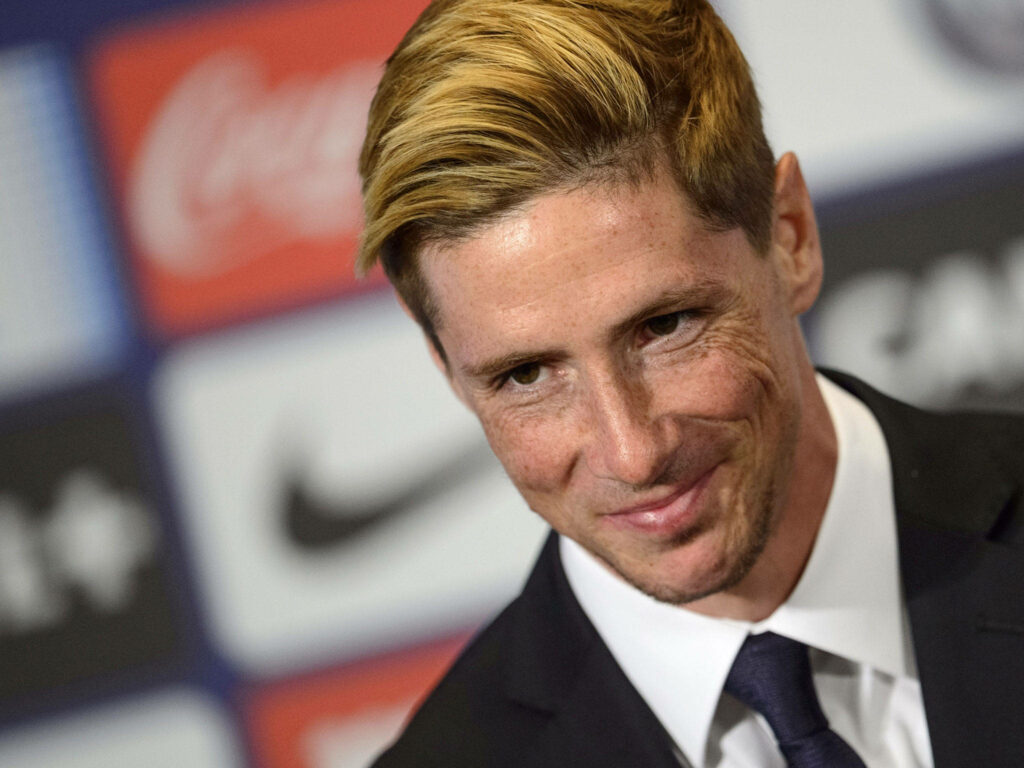 Fernando Torres in classic tuxedo smiling confidently at formal event with sponsor logo backdrop Wallpaper